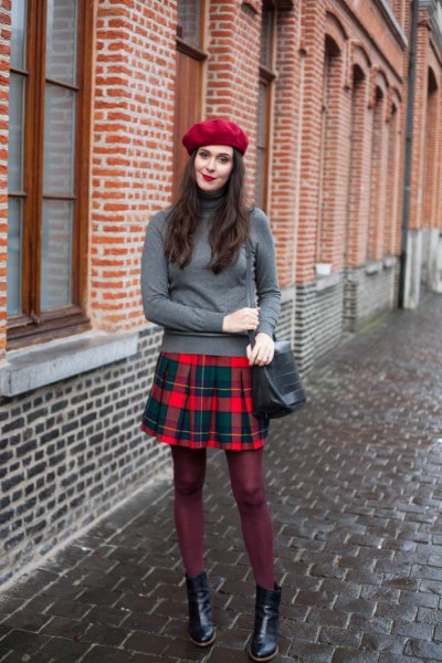 gray sweater with stand-up collar and red and blue plaid pleated skirt