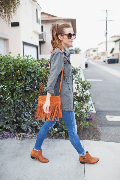 gray parka jacket with blue skinny jeans and suede bag with camel shoulder