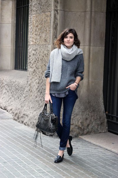 gray, ribbed, thick sweater with dark jeans with cuffs and slip-on slippers made of leather