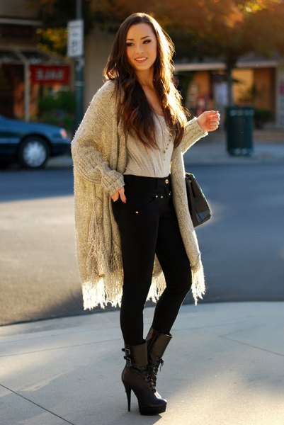 gray, ribbed longline fringe sweater with black skinny jeans and boots with high heels and medium calves