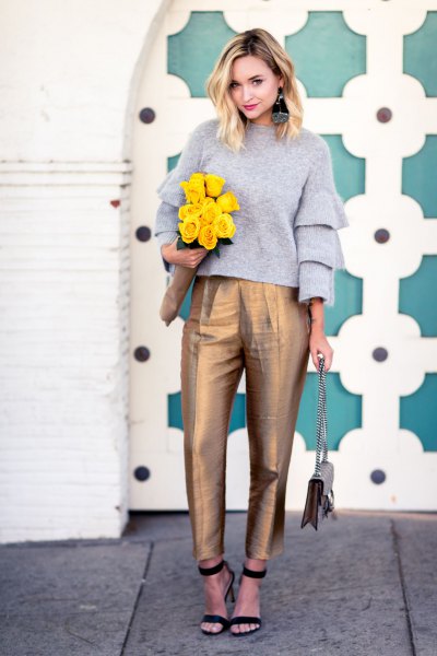 gray crew neck sweater with ruffled sleeves and gold high-waisted chinos