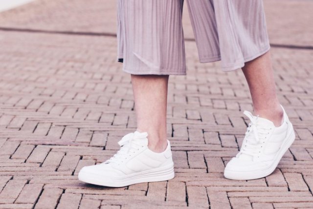 gray striped pants made of chiffon with wide legs and white sneakers