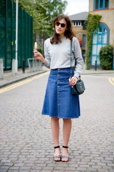 gray sweatshirt with blue, flared, knee-length denim skirt