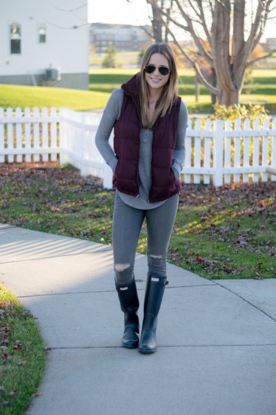 gray tunic long-sleeved T-shirt with black hooded vest and ripped jeans