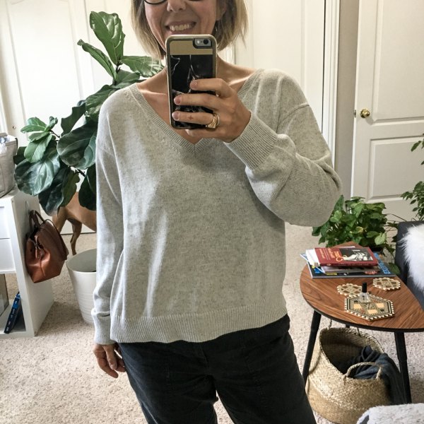 gray V-neck cotton sweater and black straight-leg jeans