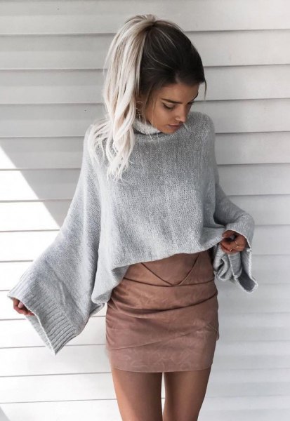 gray knitted sweater with wide sleeves and matching matt leather skirt