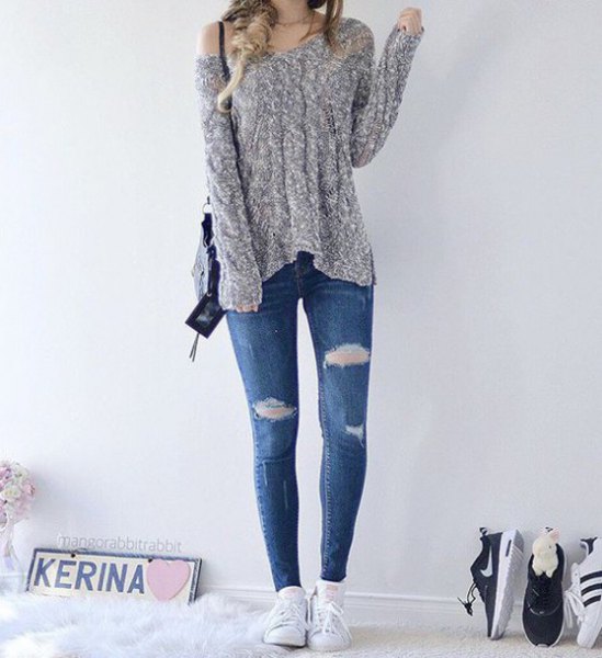 heather gray knit sweater with one shoulder and blue skinny jeans