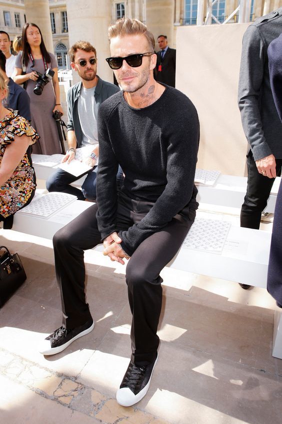 Tenue de David Beckham: Pull à col rond noir, Pantalon chino noir .