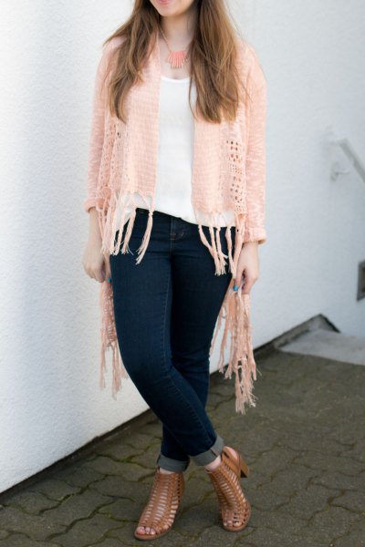 Crochet cardigan with ivory fringes, white top with a scoop neckline and dark blue skinny jeans