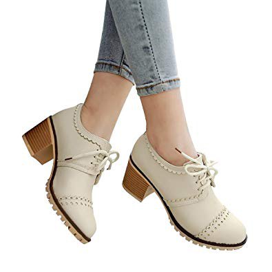 Wing-tip shoes with ivory heels and light blue skinny jeans