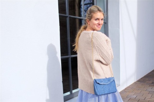 Ivory cardigan with a light blue, flared midi skirt and shoulder bag made of denim