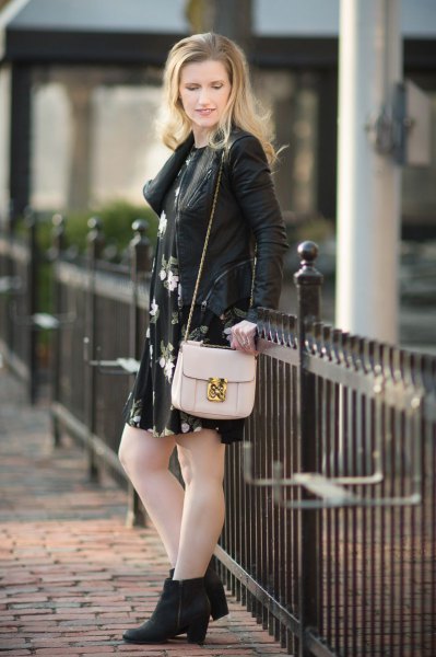 Leather jacket with a black mini dress with a flower swing and boots with heels