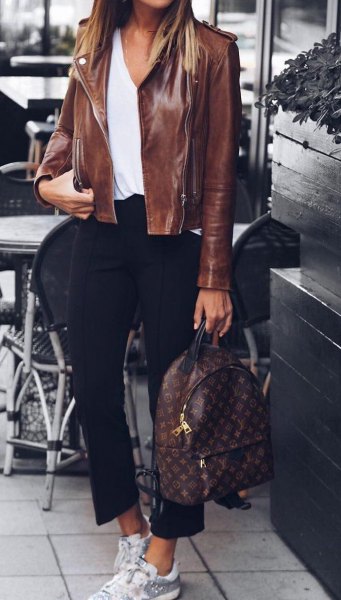 Leather jacket with a white blouse with a scoop neckline and short black pants