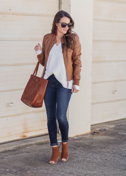 Leather jacket with a white blouse with a V-neckline and open camel boots