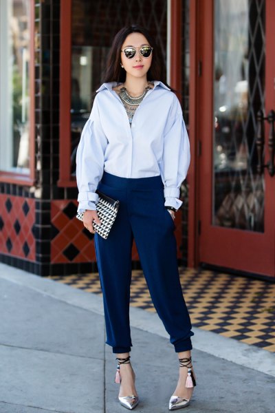 Light blue shirt with buttons and dark tapered, pleated jeans
