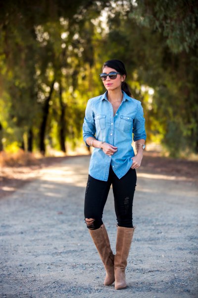 Light blue chambray shirt with buttons, black jeans and flat knee high boots made of gray suede