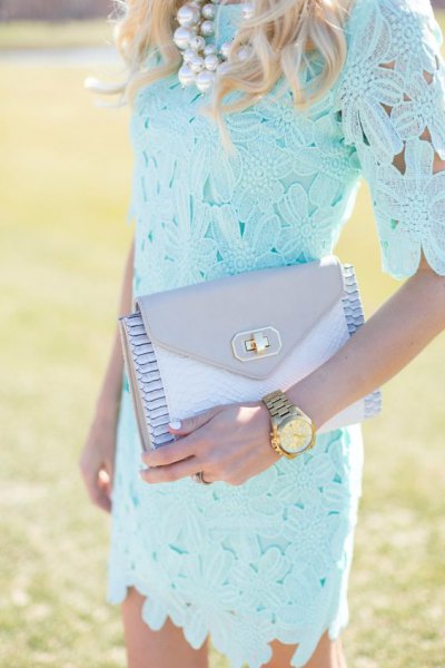 Light blue, figure-hugging lace dress with half sleeves and a matching clutch