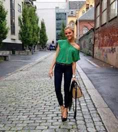 Light emerald green top with one shoulder and black skinny jeans