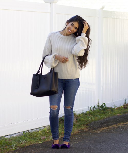 Light gray sweater with a round neckline, ripped jeans and dark blue velvet flats