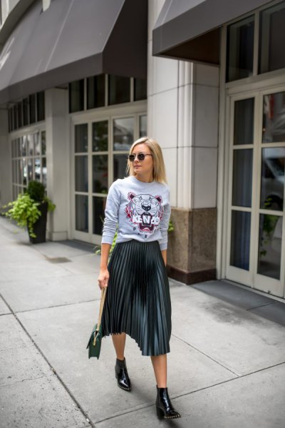 light gray graphic sweater with black pleated skirt