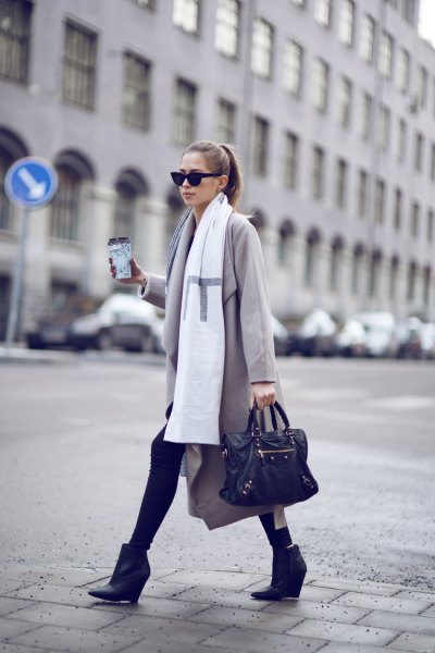 light gray longline wool coat with a white long scarf and black wedge boots made of leather