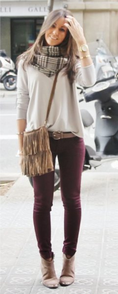light gray sweater with skinny jeans and shoulder bag with fringes