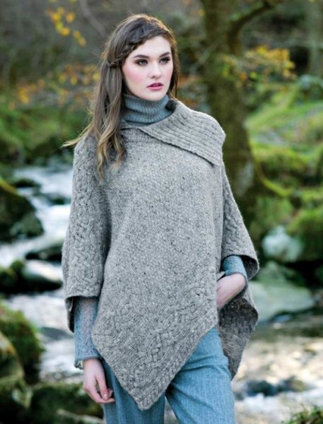 lightly mottled gray wool poncho over a ribbed knitted sweater