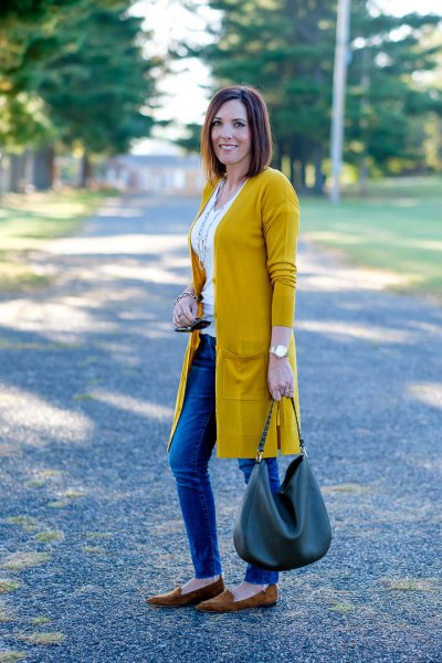 Mustard yellow longline cardigan with white vest top and blue jeans