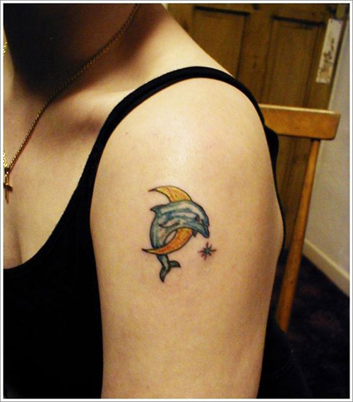 Moon dolphin tattoo on side of shoulder