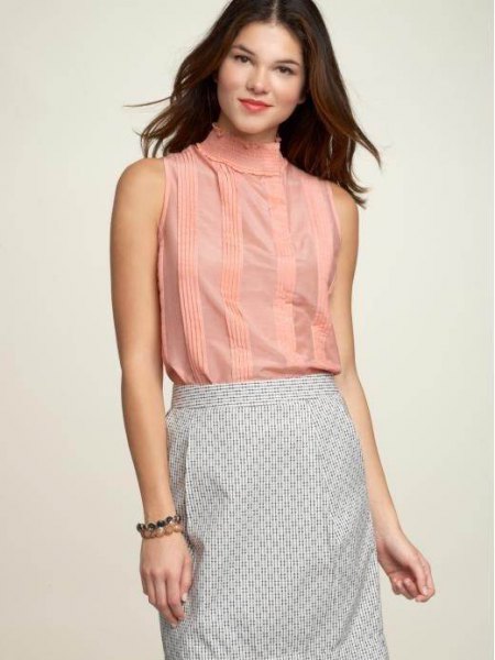 sleeveless blouse with a stand-up collar and a black and white striped pencil skirt