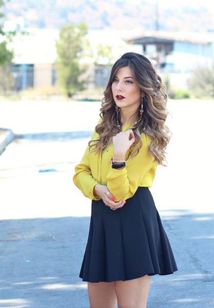 Mustard-colored shirt with buttons and black minirater skirt