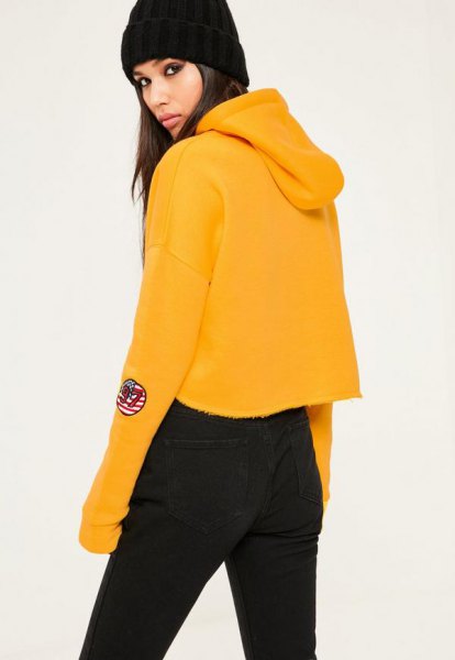 Mustard yellow cropped hoodie with black high-waisted jeans