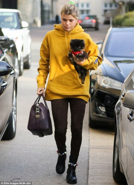 mustard yellow long hoodie with black leggings and ankle boots