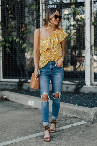Mustard yellow top with a shoulder ruffle and ripped jeans