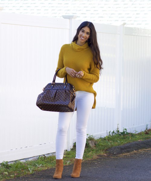 Mustard-yellow, ribbed sweater with a cowl neckline and white skinny jeans