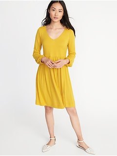 Mustard yellow dress with V-neckline and flared knee with white flats