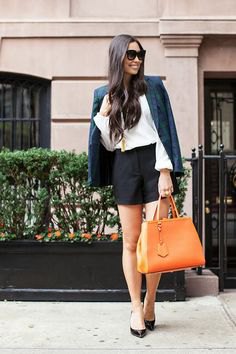 Navy blazer with black, flowing shorts and leather handbag
