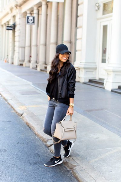 Navy blue baseball cap with black aviator jacket and sneakers