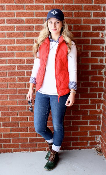 Navy blue baseball cap with white sweater and quilted vest