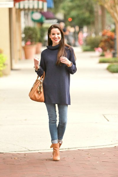 Dark blue long-sleeved turtleneck tunic with cuffed jeans and orange-colored boots