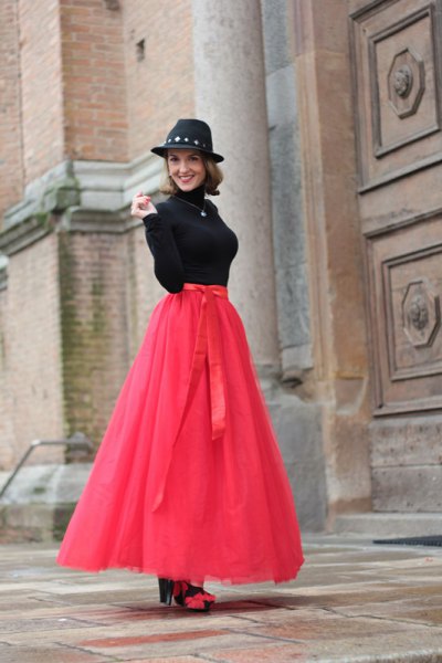 Neon pink long tulle skirt with black sweater and felt hat