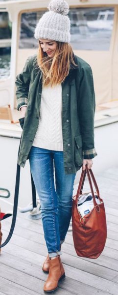 Olive green jacket with white knitted sweater and leather boots