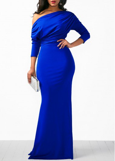 A strapless royal blue long-sleeved dress with a white clutch wallet