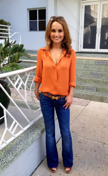 orange chiffon shirt with buttons and blue flared jeans