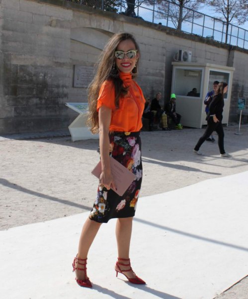 orange short-sleeved shirt with buttons and black midi skirt with floral pattern