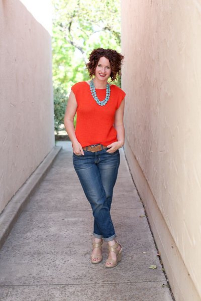 orange blouse with cap sleeves, jeans with cuffs and brown belt