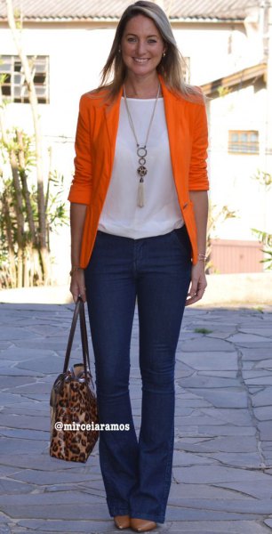 Orange half-sleeve blazer with a white top and dark blue flared jeans