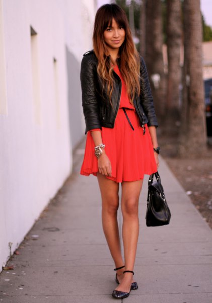 orange mini dress with black leather jacket and leather straps with ankle straps