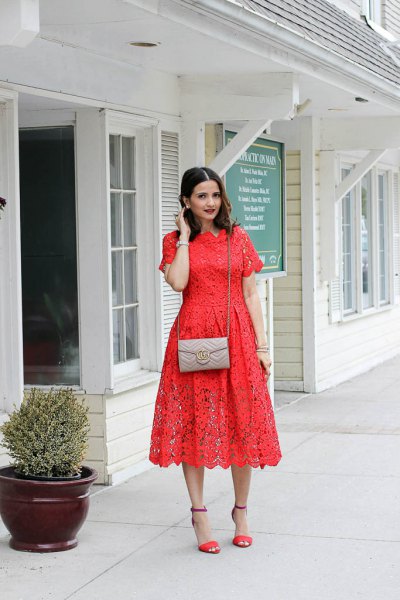 Orange short-sleeved midi lace dress with a blushing pink small purse