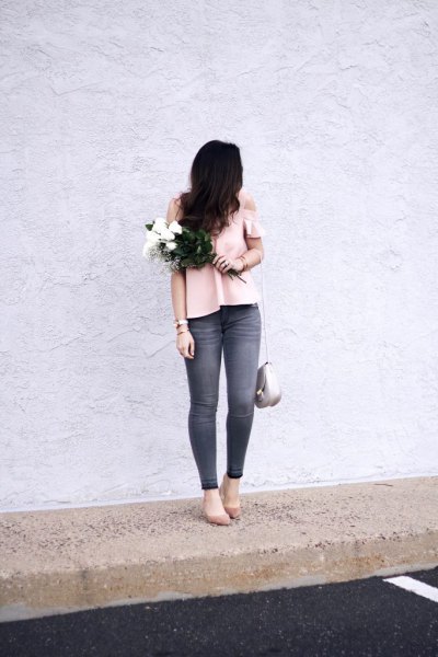 Light pink top with a cold shoulder and gray skinny jeans